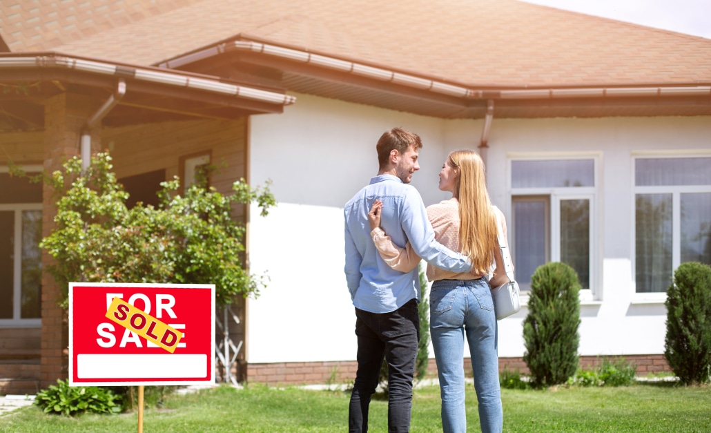 Newlywed couple standing in front yard of their new residential property, blank space